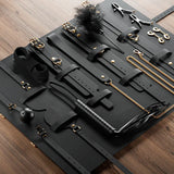 Kit BDSM Luxe 12 Pièces : pochette ouverte sur parquet, noir